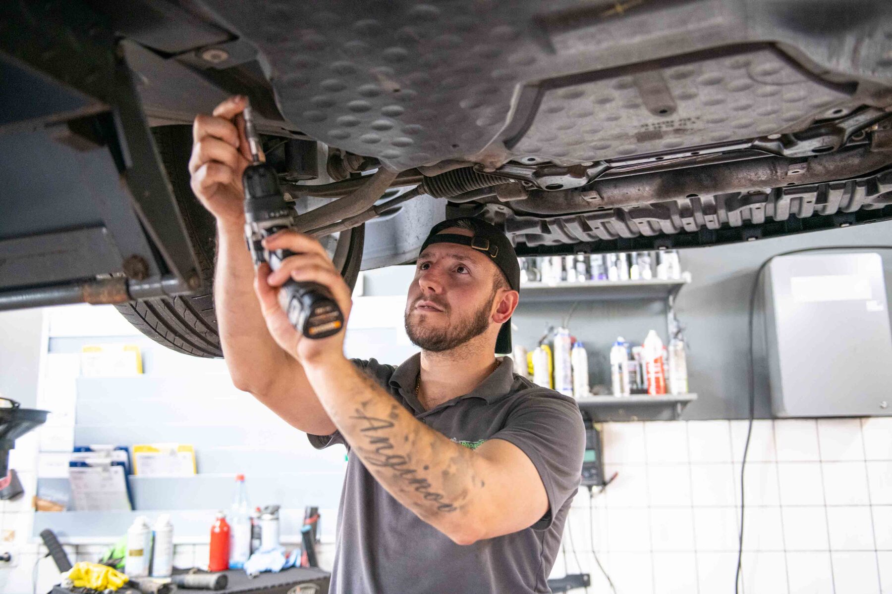 Mechaniker bei Arbeiten an einem Fahrzeug auf der Hebebühne