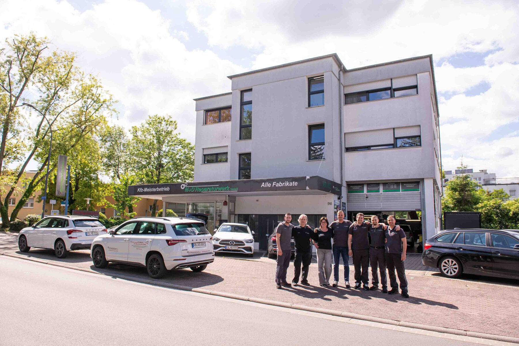 Außenaufnahme des Betriebsgebäudes mit dem Team davor